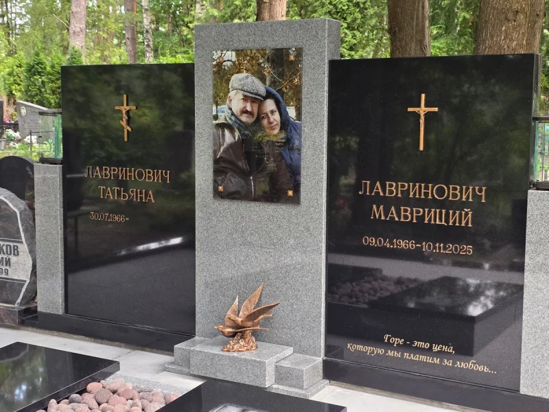 Trīsdaļīgs kapu piemineklis ar stikla portretu no divu krāsu granīta ar bronzas burtiem un aksesuāriem.